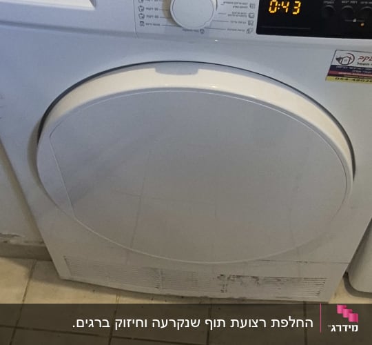 מייבש כביסה עם תצוגה דיגיטלית וכבל חשמל מונח עליו